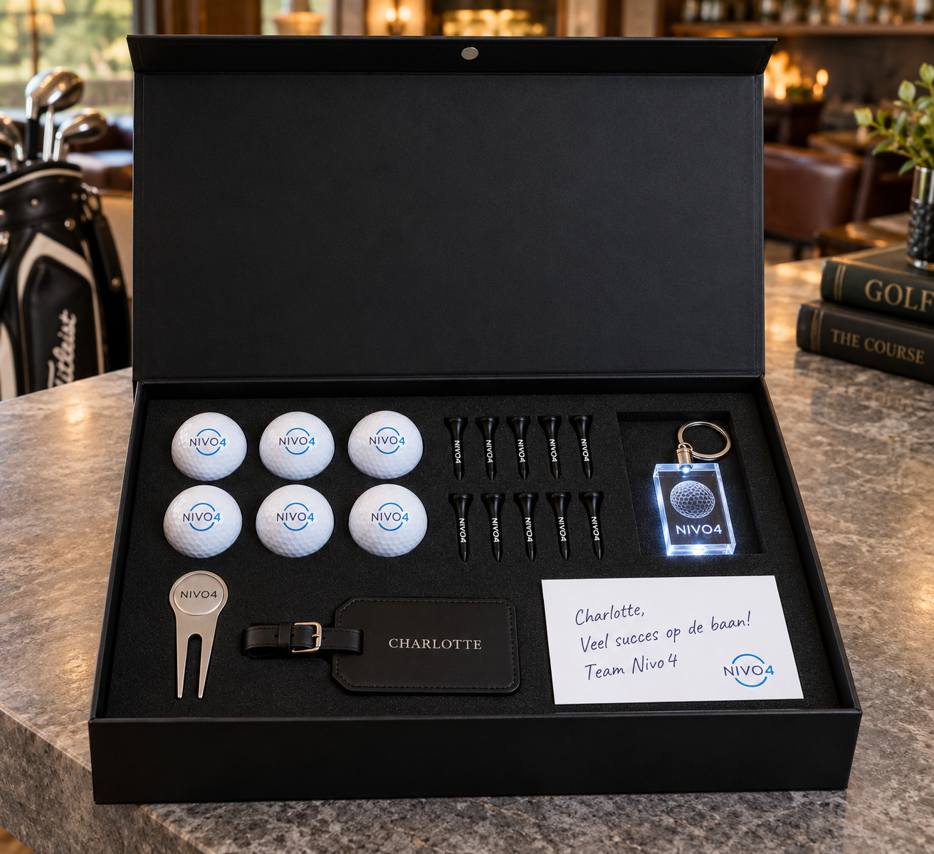 Black 30 × 40 × 10 cm Nivo4 presentation box with six individually UV-printed golf balls, ten tees, crystal keychain, pitchfork, luggage tag and personal note